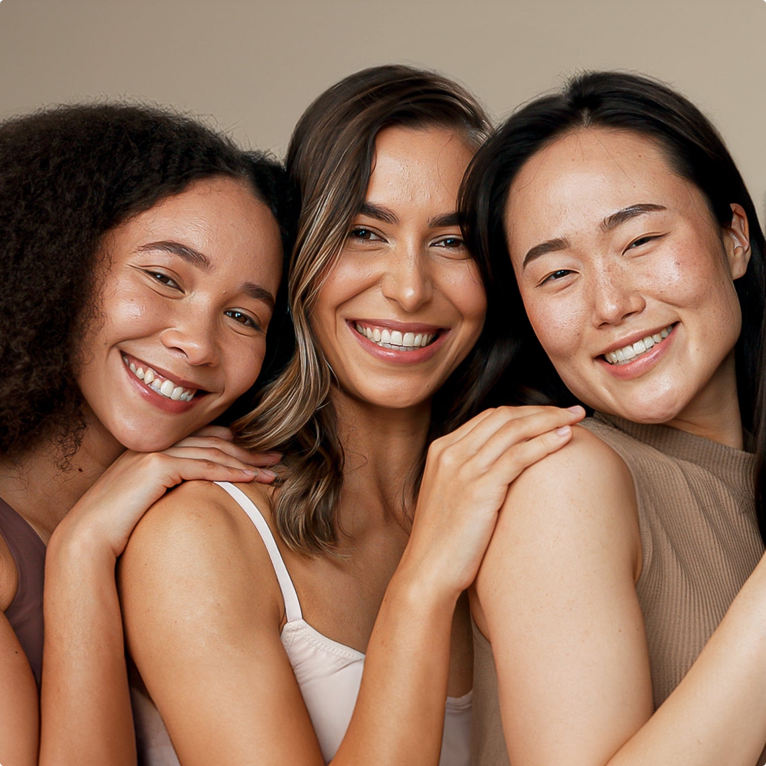 Three women looking directly ahead and smiling broadly