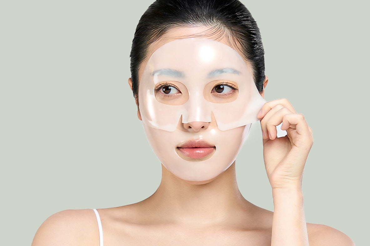 A model holding the edge of a face mask with one hand and peeling it off