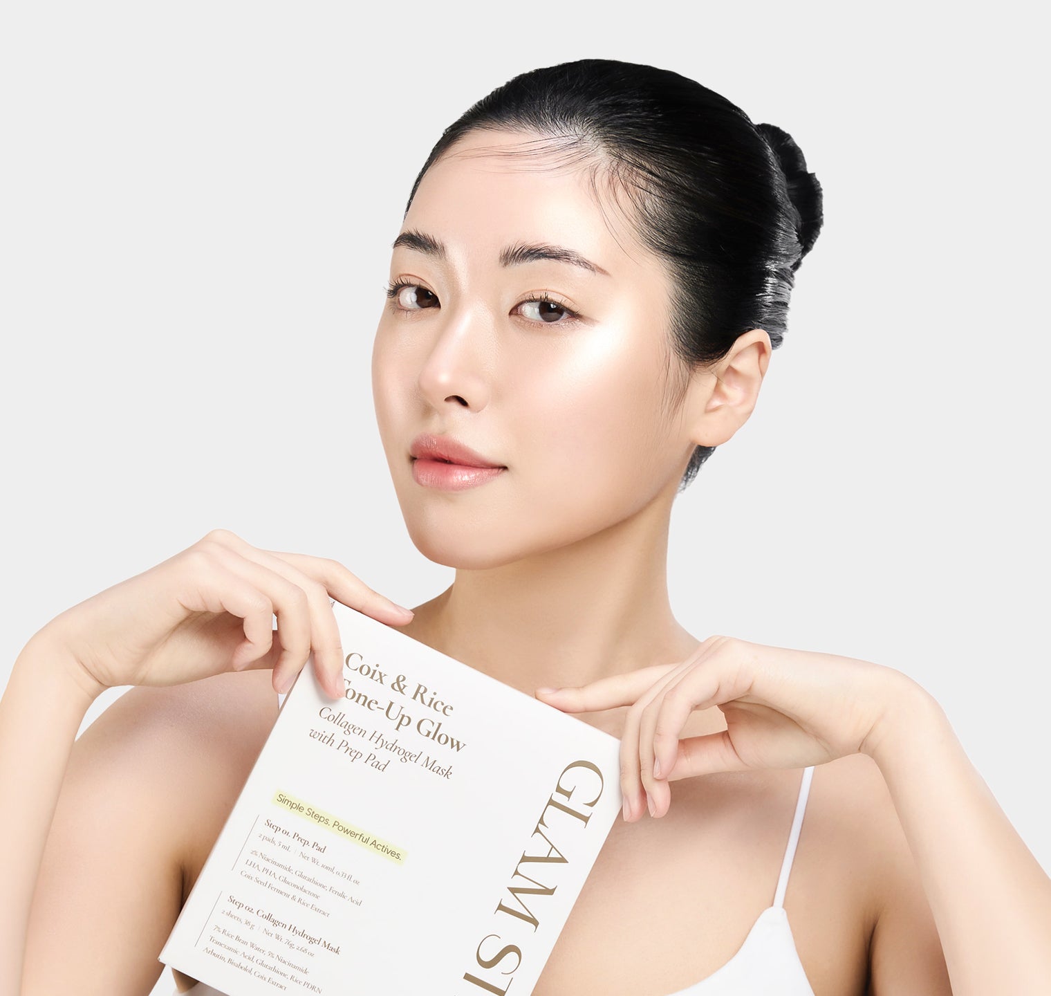 Model holding the Coix & Rice Tone-up Glow package and looking at the camera